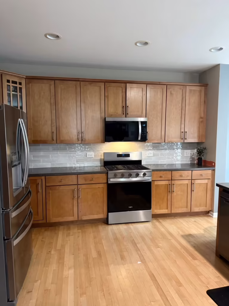 Honey oak cabinets with gray counters and subway tile before refacing