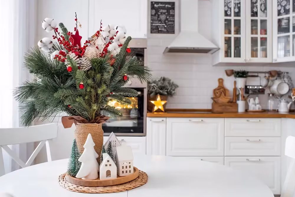 White kitchen decorated for Christmas with a festive arrangement