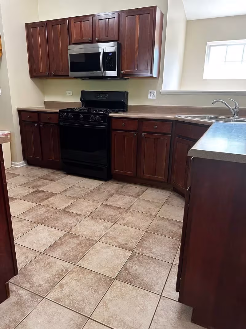 Cherry cabinets and tiled flooring in a South Elgin kitchen awaiting refacing