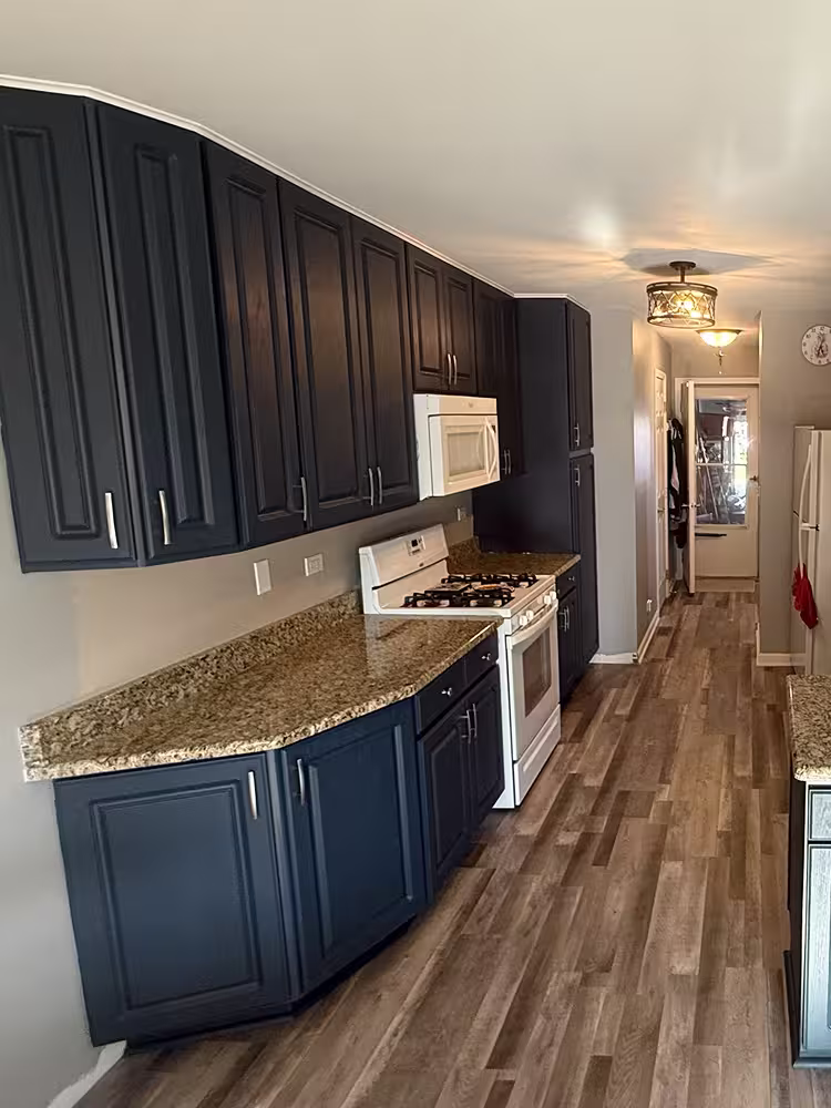 Dark navy galley cabinets with brown granite counters after refacing