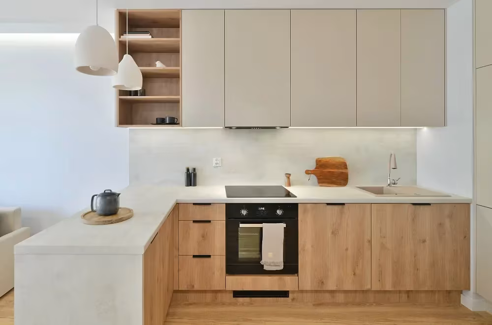Cream upper cabinets above light wood base units in a current white kitchen