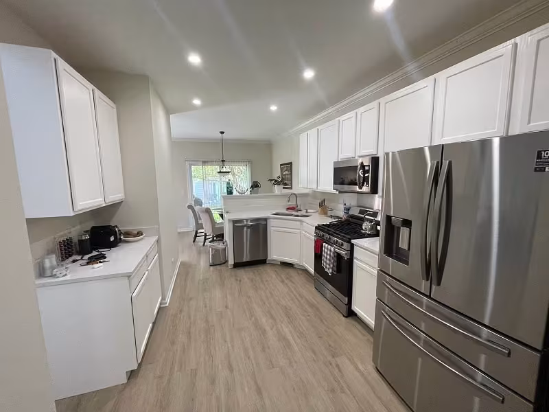 White refaced cabinets running the length of the galley kitchen