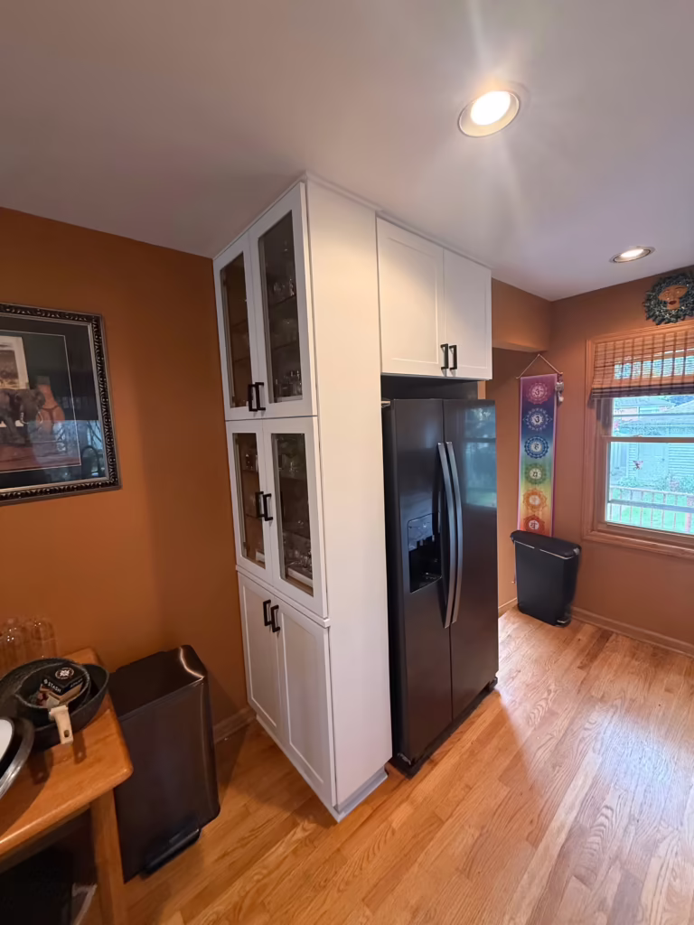 Tall white pantry cabinet added when the oak kitchen was refaced