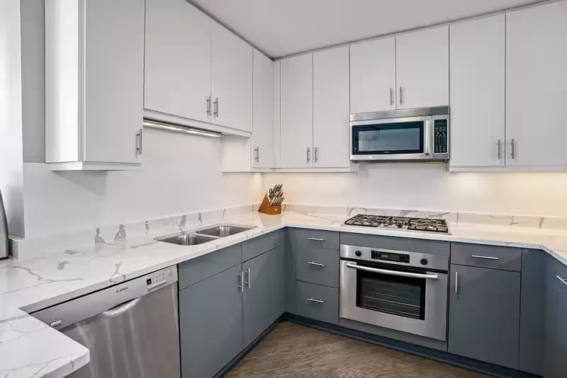 White upper cabinets above gray base units after a cabinet door replacement