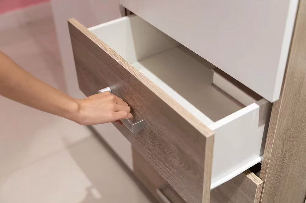 Hand opening a woodgrain laminate drawer front