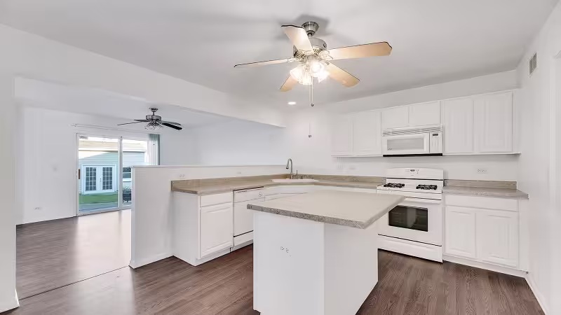 White cabinets and island over hardwood in a refaced Chicagoland kitchen