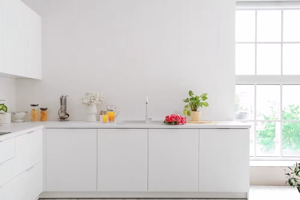 Minimal white kitchen with handleless lower cabinets