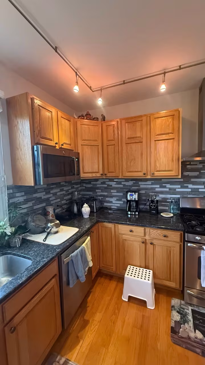 Honey oak cabinets with a blue glass mosaic backsplash before refacing