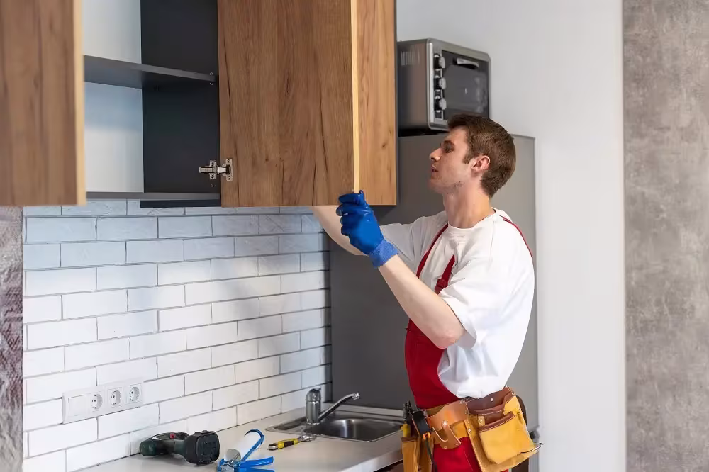 Installer in an apron fitting a wood wall cabinet