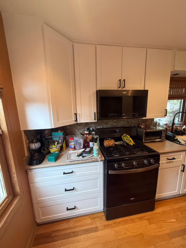 White refaced uppers above the black range in the finished kitchen