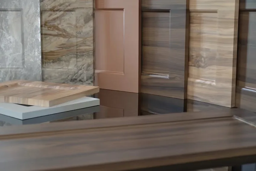 Stone-look and woodgrain 3D laminate panels stacked as a finish palette