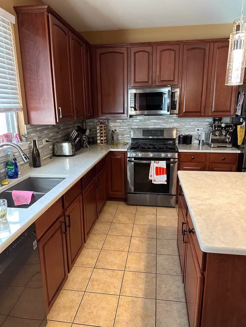 Cherry raised panel cabinets over tile flooring before refacing