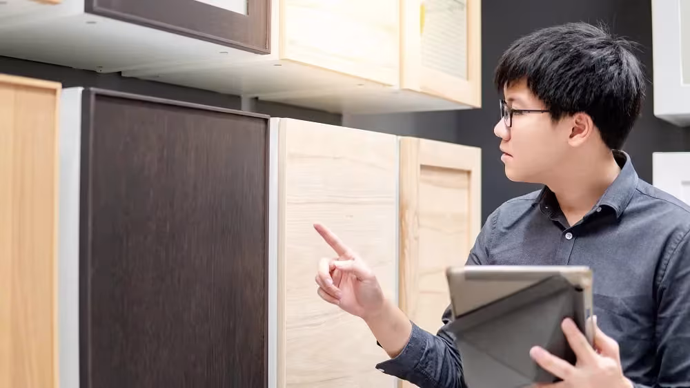 Man with a notebook comparing cabinet door samples