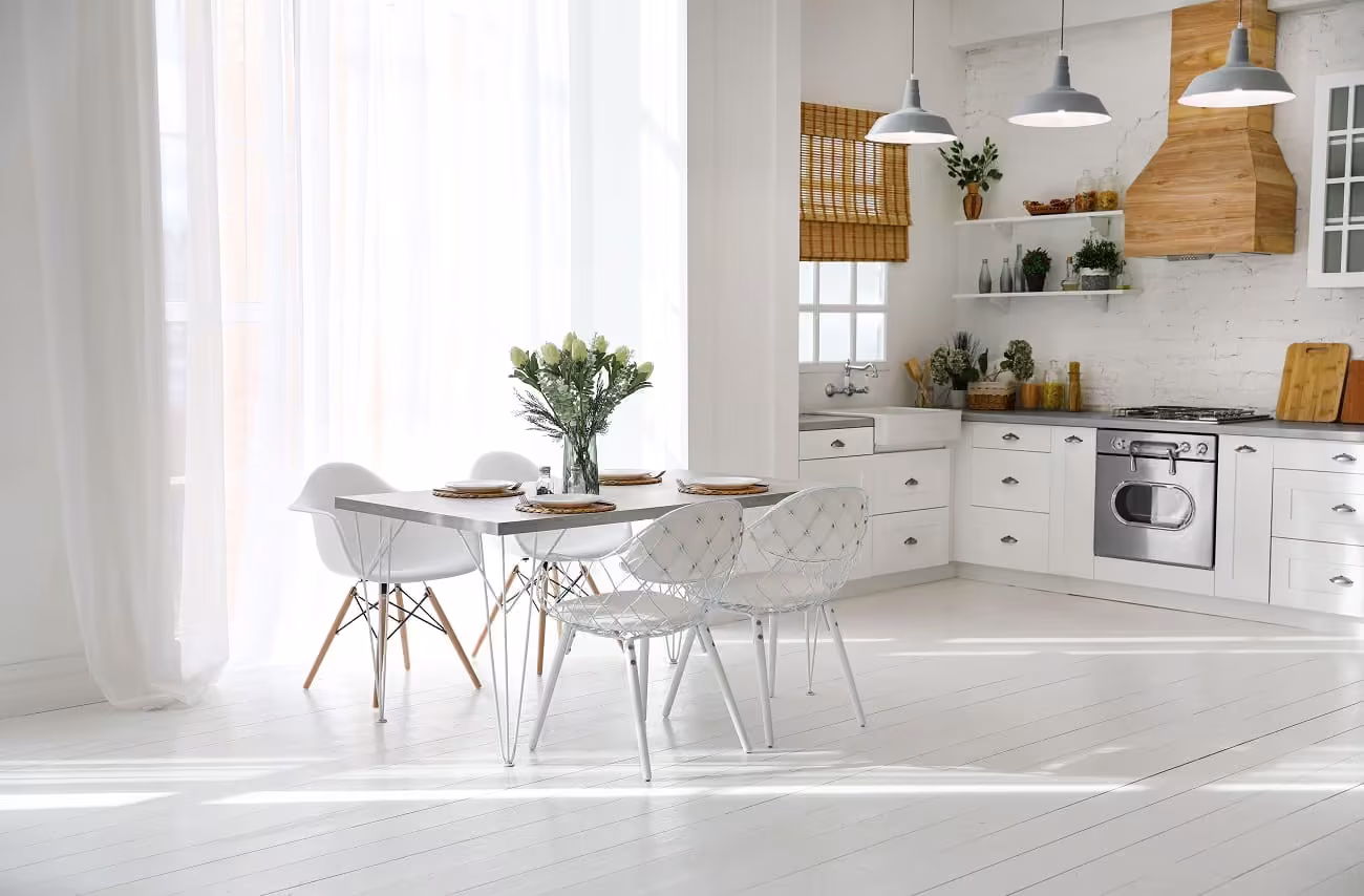 Bright white kitchen with rattan pendants and a dining set in Warrenville
