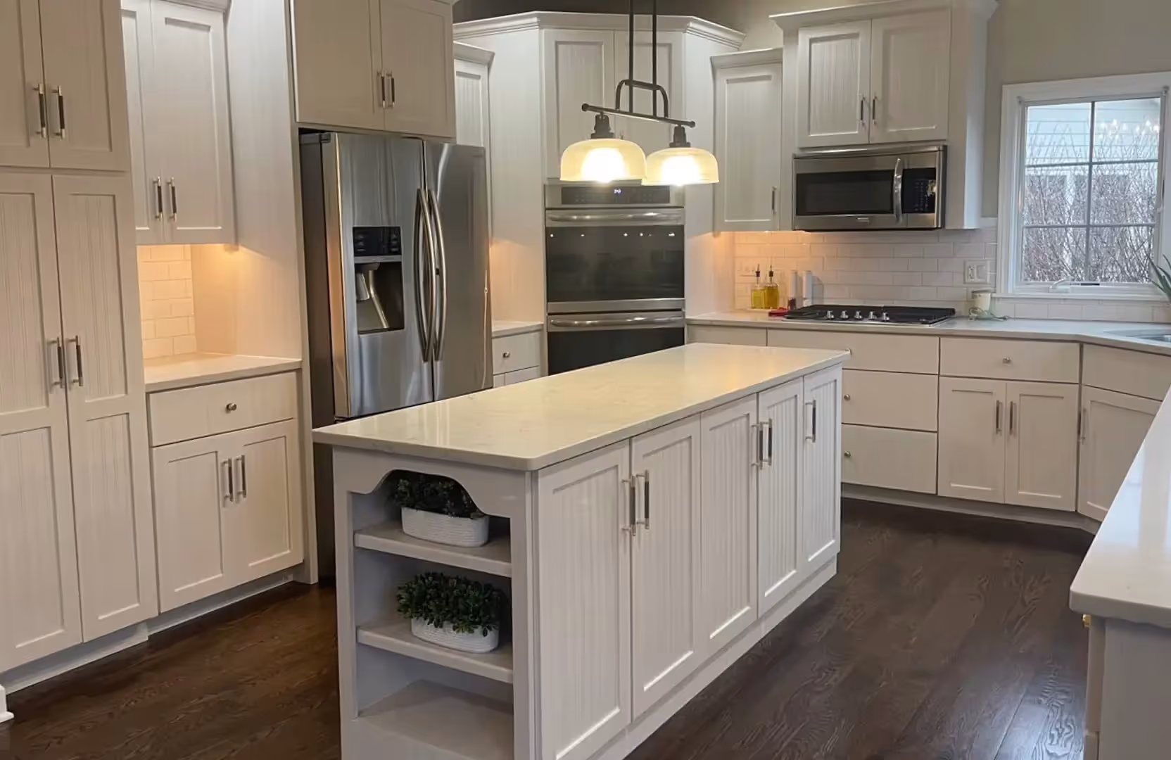 White kitchen with an island lit by pendants at the final quality check