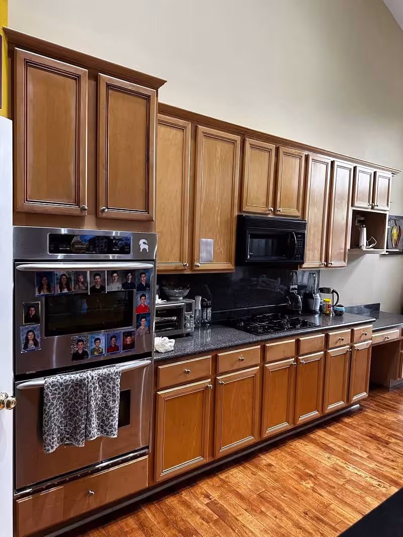 Medium oak cabinets and a black cooktop in a Northbrook kitchen before refacing