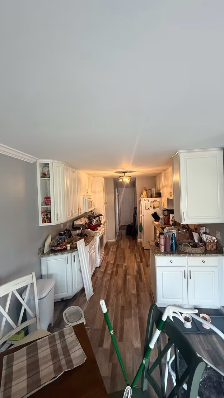 Cream galley kitchen looking dated and cluttered before the navy refacing