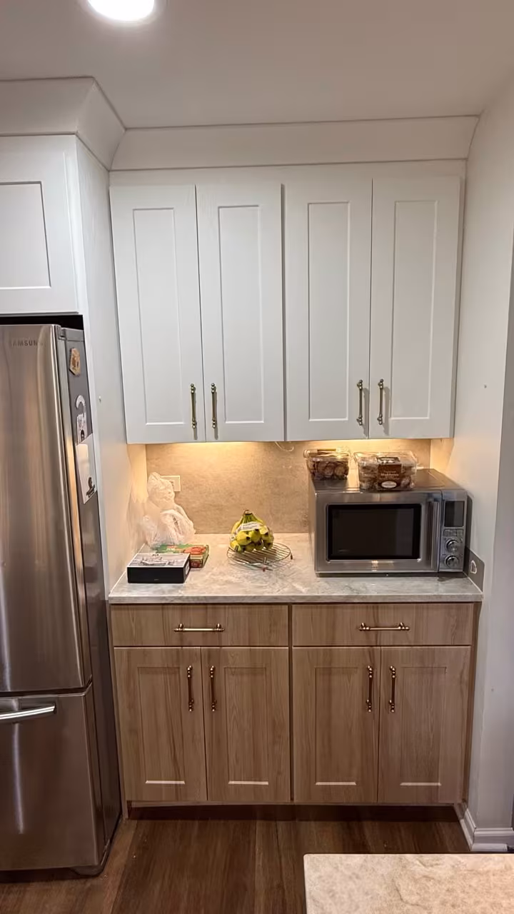 Natural wood base cabinets under white uppers after the two-tone refacing