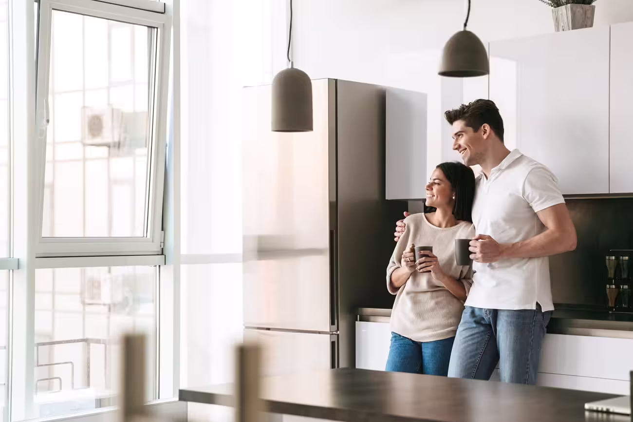 Couple with coffee in a dark modern kitchen with matte cabinets