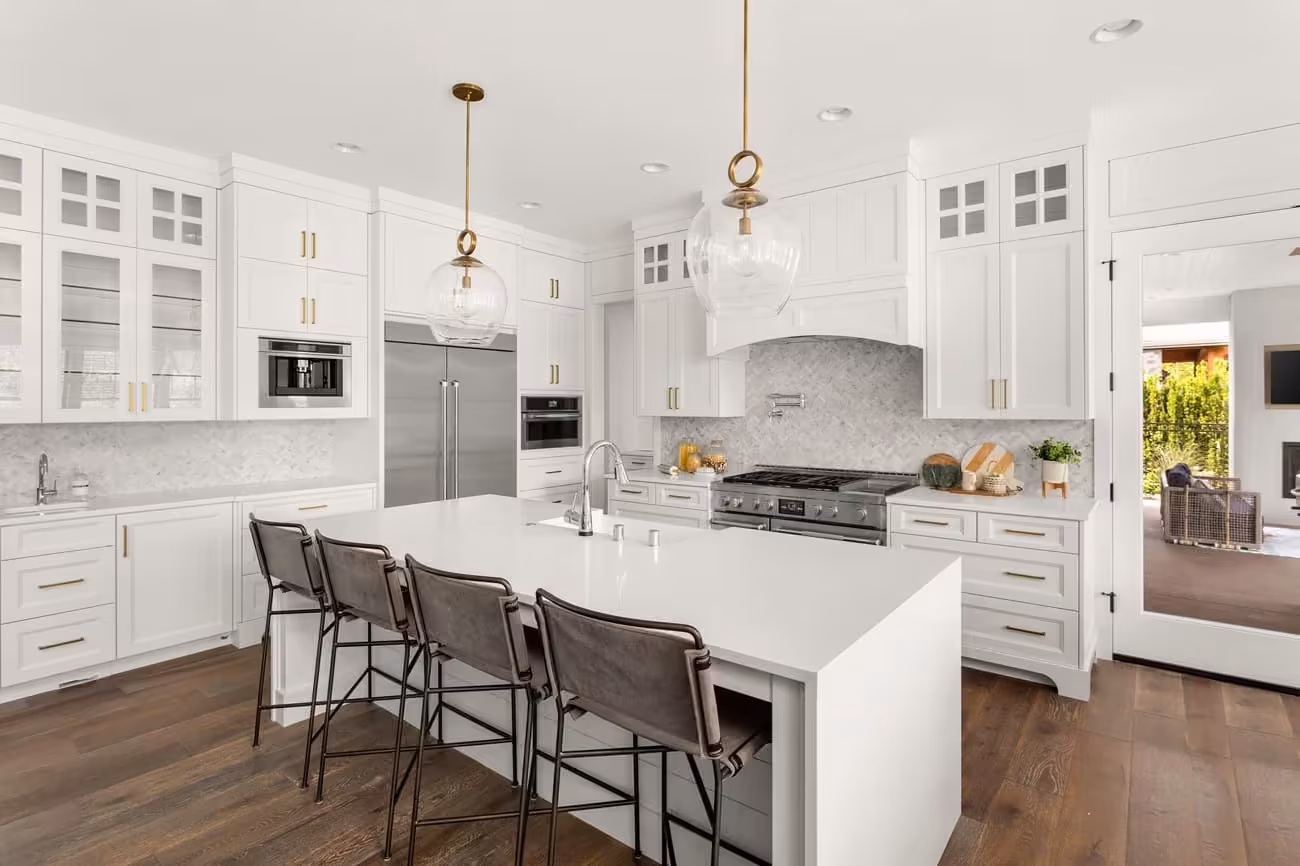 White kitchen with a long island and brass pendant lights in Batavia