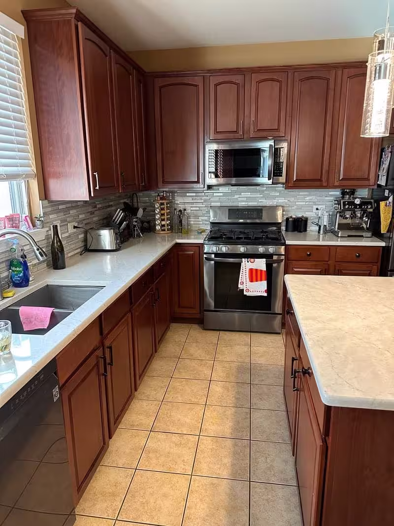 Raised panel cherry cabinets and tile flooring awaiting a refacing project