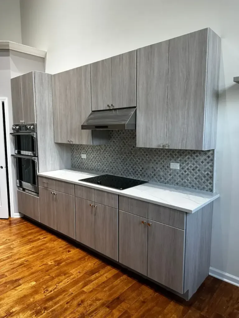 Gray woodgrain slab doors and a mosaic backsplash after the Northbrook replacement