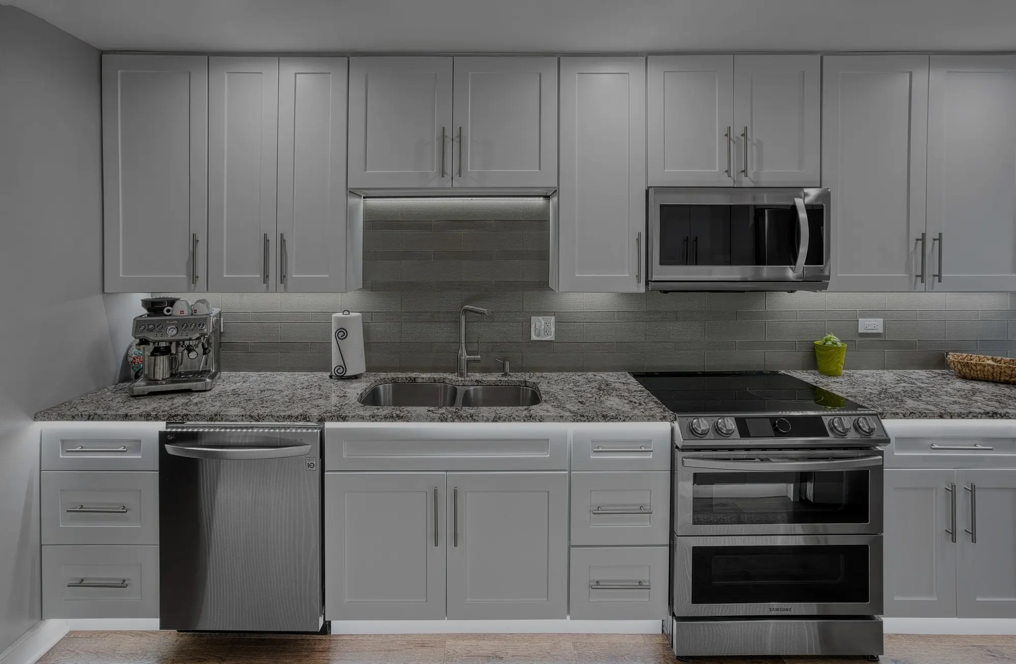 Gray Shaker kitchen with stainless appliances and a granite countertop